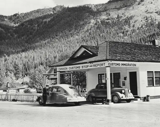 Vintage photograph. A United States motorist goes through Canada customs at Kingsgate British Columbia