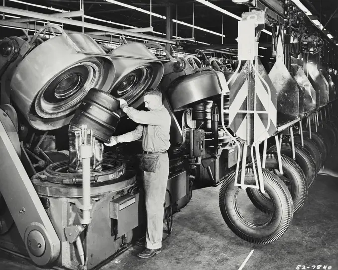 Vintage photograph. The automatic units combining the tire forming and the tire curing operations and increase the output of finished tires at the Des Moines plant of the Firestone Tire and Rubber Company