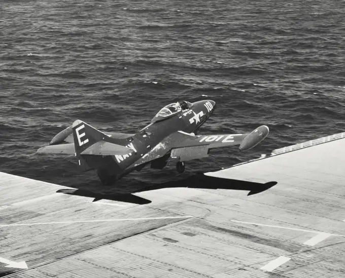 US Navy F9F Blue Angel flies over deck following touch and go off carrier flight deck