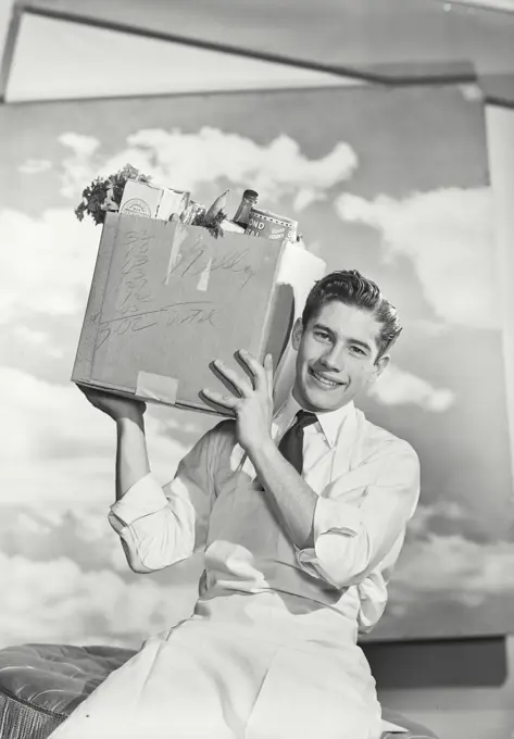 Vintage photograph. Portrait of grocery boy with delivery box of groceries