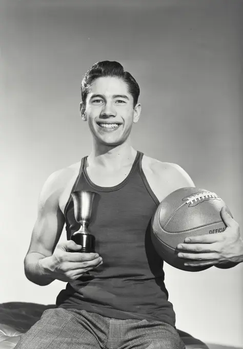 Vintage photograph. Portrait of young man with basketball and trophy