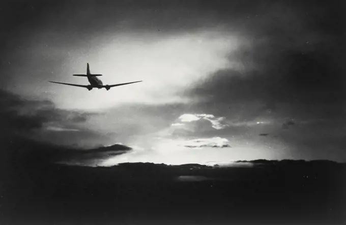 Vintage photograph. Silhouette of Airplane flying in the clouds