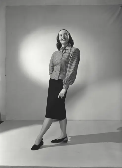 Woman in striped blouse smiling off camera