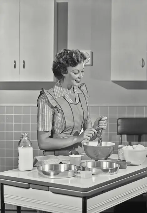 Vintage photograph. Woman mixing ingredients in bowl.