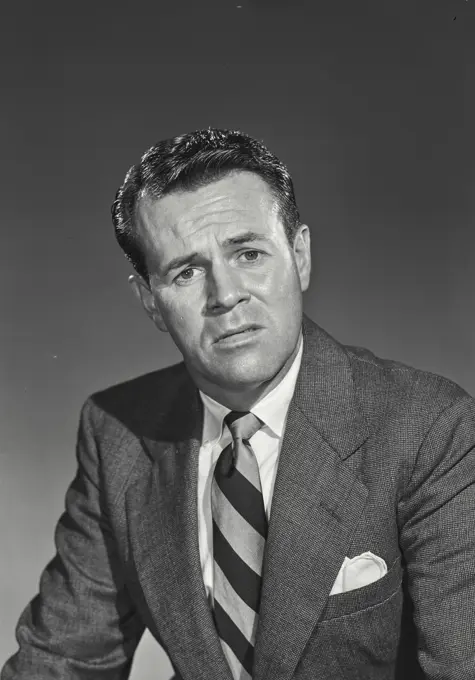 Vintage photograph. Man in suit and tie looking at camera with concerned expression