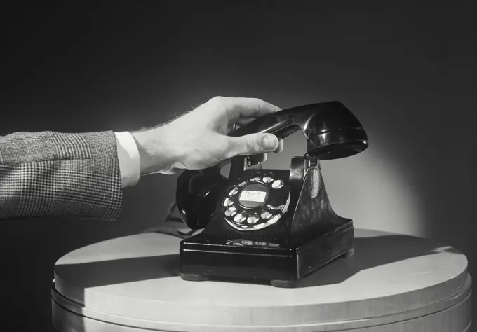 Hand placing telephone back on dial