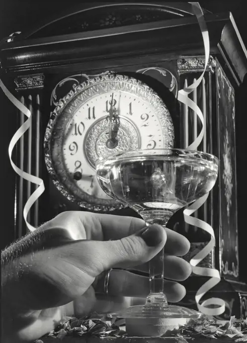 Hand holding glass at New Years Eve scene