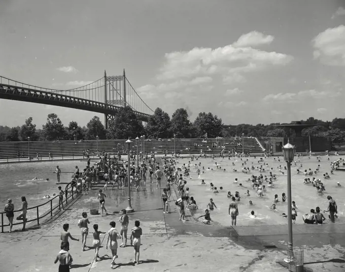 Vintage photograph. Astoria Park Pool. New York City. People playing in public pool with bridge in background