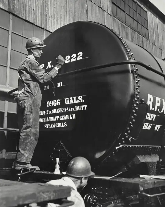 Vintage photograph. Tank car emerging from Shell Oil Company's tank car repair shop at the Wood River, Illinois refinery. It is being lettered with the information required by the railroad