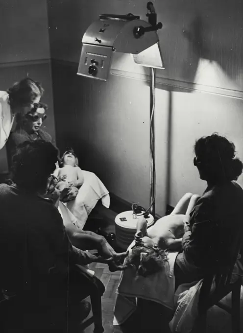 Vintage photograph. Children at Birmingham's Child Welfare Center getting sun-ray treatment. Children who attend Britain's Welfare Centers can benefit from the latest advances in this promising field of ray-therapy. Modern medical and scientific research have proven the value of ultraviolet ray treatment, especially during winter months