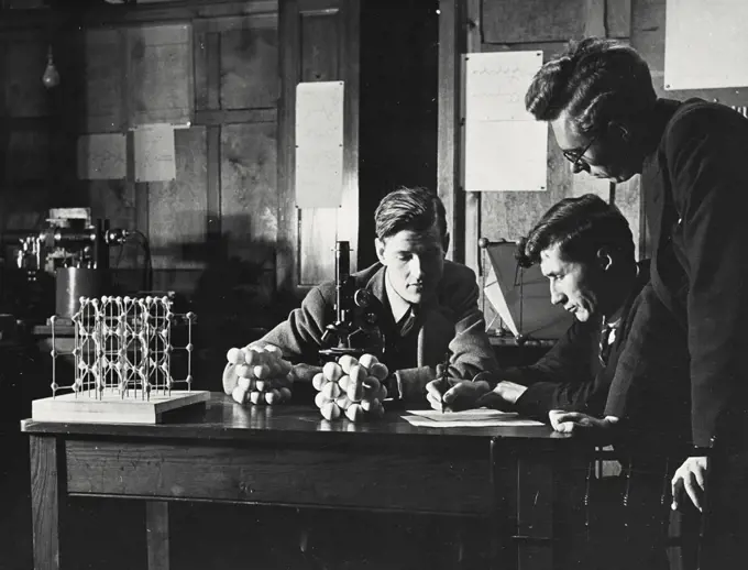 Vintage photograph. Dr WH Taylor discussing with his colleagues the analysis of crystal structure from X-ray data, Faculty of Technology, University of Manchester, England