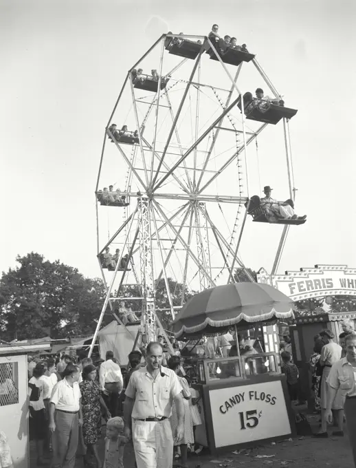 Vintage photograph. Carnival scene showing ferris-wheel and crowds