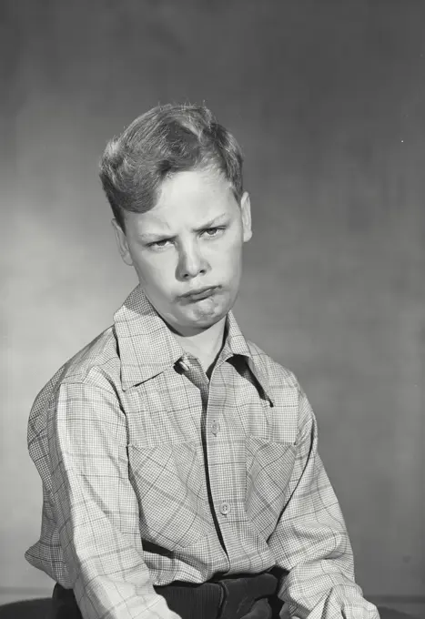 Vintage photograph. Boy wearing button up shirt making comical expression