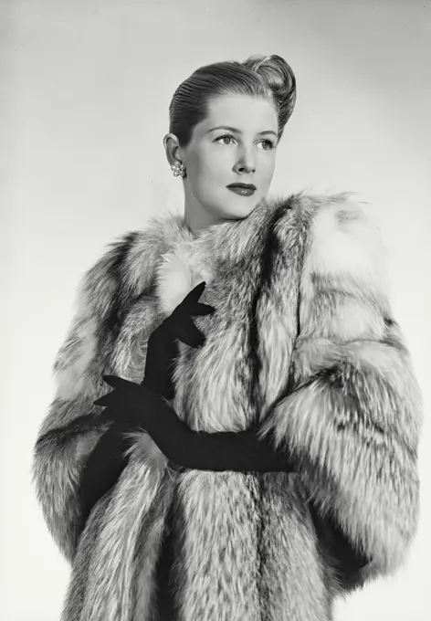 Vintage photograph. Woman in luxurious fur coat looking away