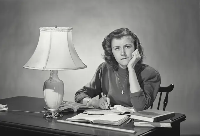 Vintage photograph. Woman at desk resting head on hand thinking