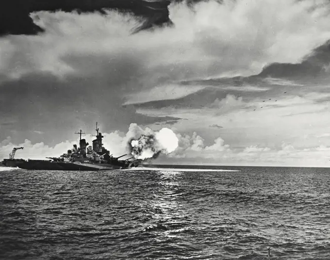 USS Missouri is shown as the 16 inch guns of her two forward turrets fire in salvo