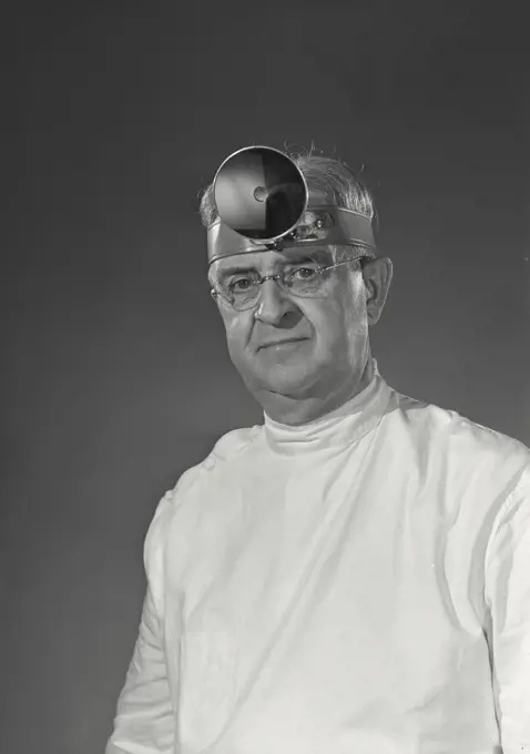 Doctor wearing head mirror looking ahead