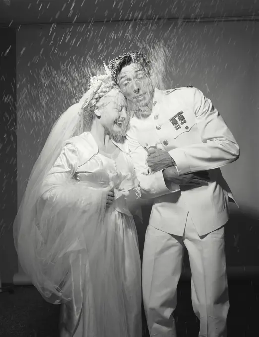 Man and wife being showered with rice during wedding