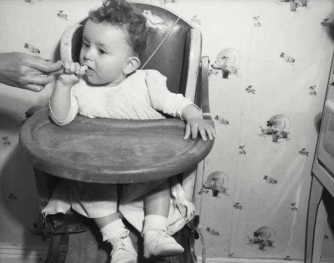 Baby in high chair being fed