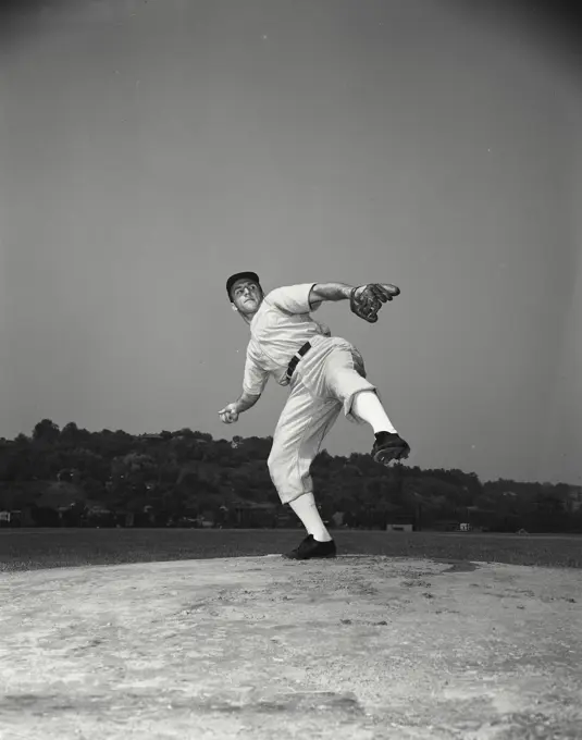 Baseball pitcher cranking up to throw ball