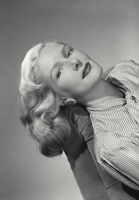 Woman in striped blouse laying on couch.