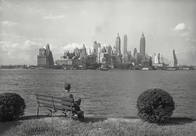 Man sitting on bench admiring Lower Manhattan skyline