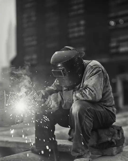 Welder wearing mask doing rod welding