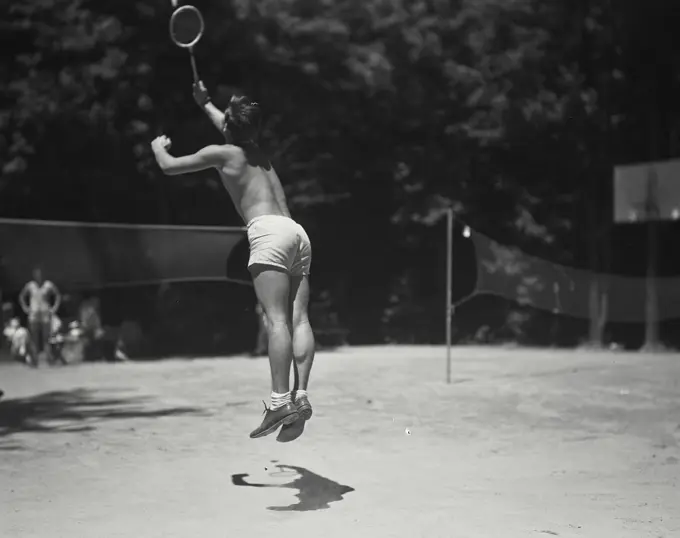 Man jumping during badminton play at Camp Beaverbrook