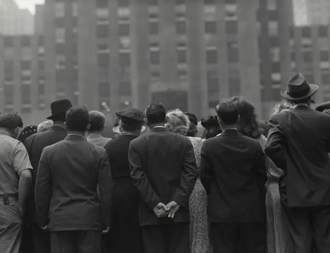 Crowd of people on street viewed from behind