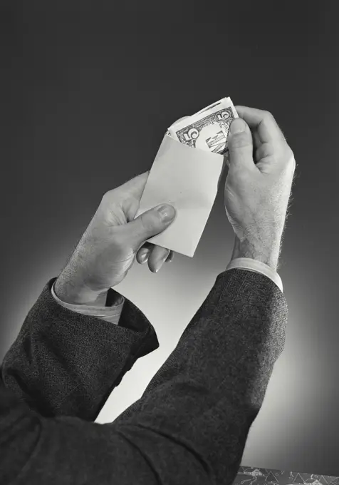 Five dollar bill being folded into envelope