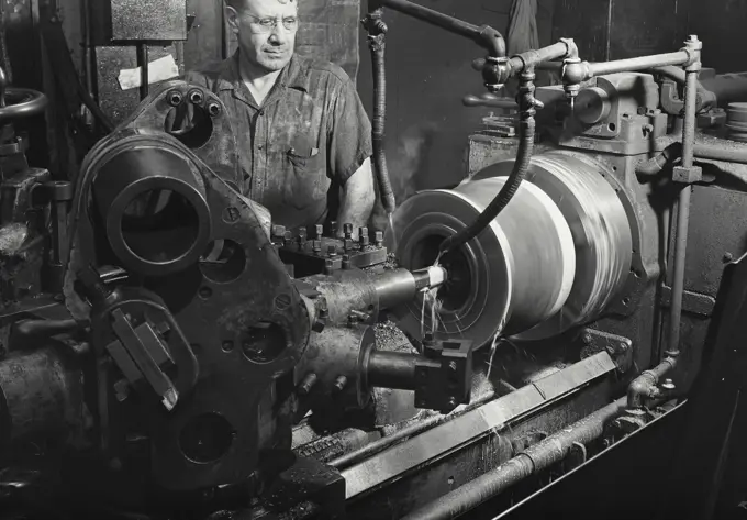 Worker standing behind multiple tooling machine in operation, Worthington Pump and Machinery Corporation, Harrison, New Jersey