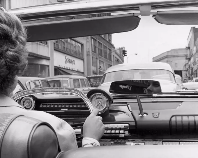 Rear view of a woman driving a convertible car