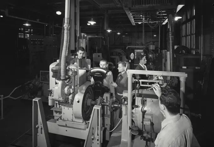 Vintage Photograph. Group of students of Stevens Institute of Technology runs a dynamometer test of a two cycle general motors diesel engine