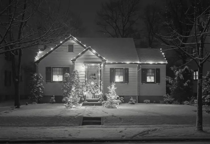 Vintage Photograph. Small house with lights and cut out figures, decorations for the Christmas Holidays