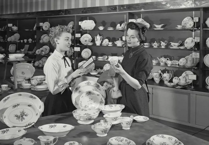 Vintage Photograph. Woman shopping for new dinnerware