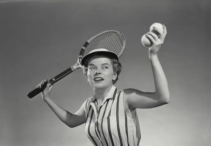 Vintage Photograph. Woman throwing up tennis ball to serve