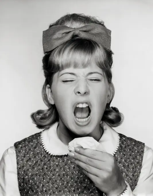 Close-up of a teenage girl sneezing