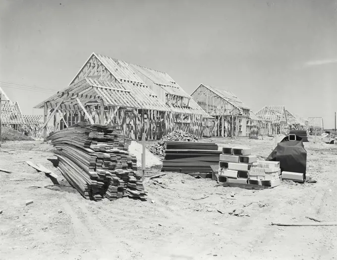 Vintage photograph. Scene in subdivision, houses under construction, pile of bricks, framed houses, Levittown, Long Island, New York State, USA