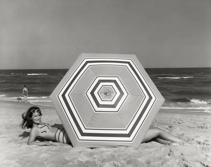 Side profile of young woman lying on beach