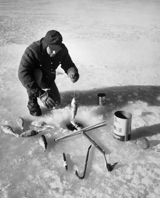 High angle view of a mid adult man fishing on ice