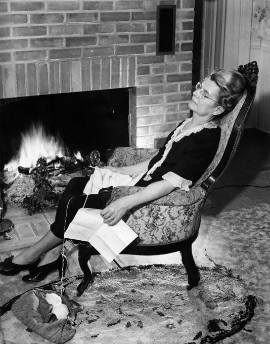 Woman napping in front of fireplace