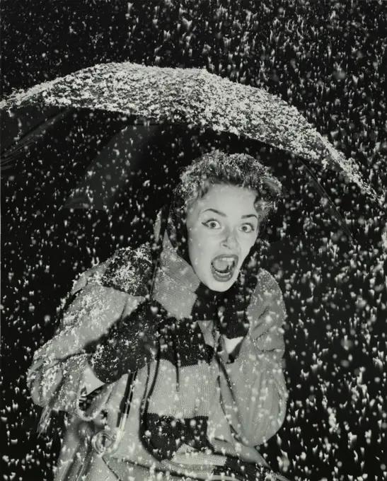 Young women holding an umbrella in the snow