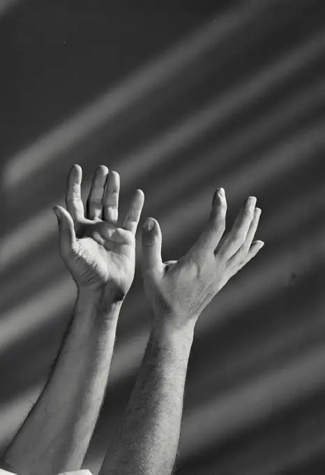 Vintage Photograph. Male hands seen held open with light shining. Frame 1