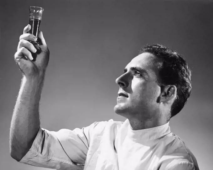 Vintage Photograph. Male chemist studying chemical in test tube