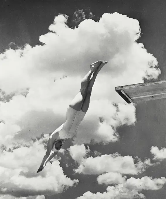 Vintage Photograph. Woman diving from diving board with clouds in sky