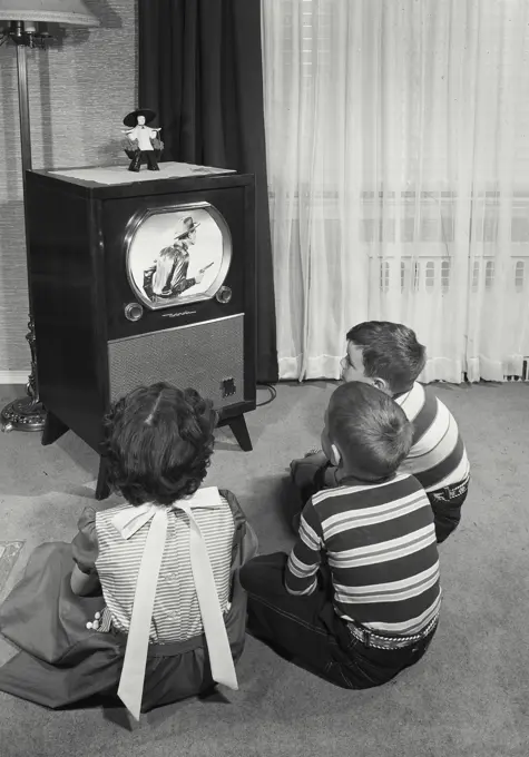 Vintage Photograph. Children sitting on floor and watching television.