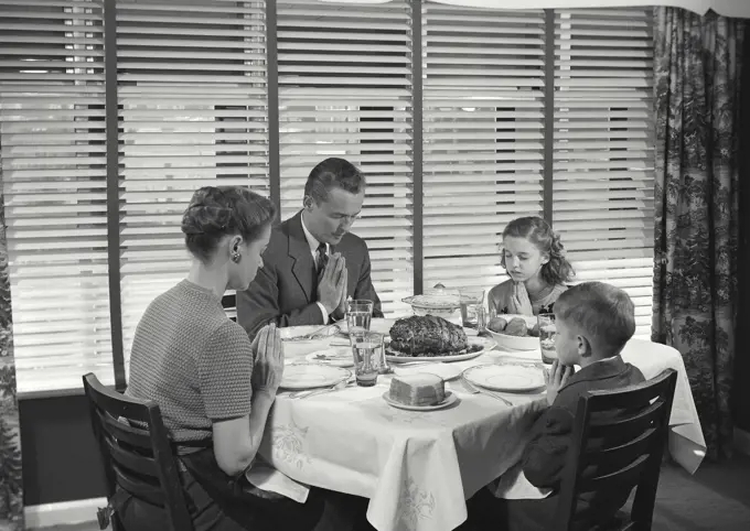 Vintage Photograph. Family at table praying before dinner. Frame 1