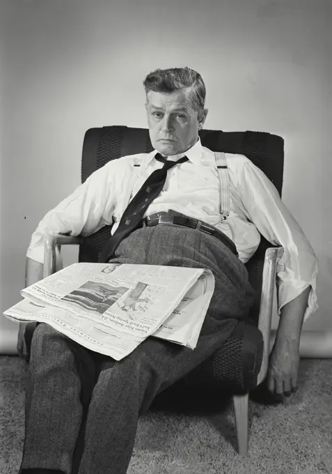 Vintage Photograph. Tired man sitting in chair with newspaper. Frame 2