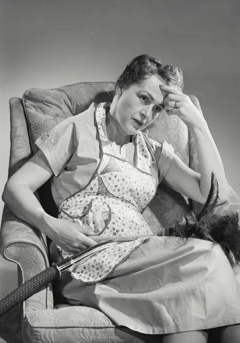 Vintage Photograph. Tired woman in apron sitting in chair from cleaning. Frame 3