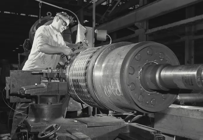 Vintage Photograph. New York Central Railroad shop man soldering wire on armature bending machine wearing goggles, Frame 2